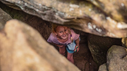 Girl peeking up through rocks at Brimham Rocks